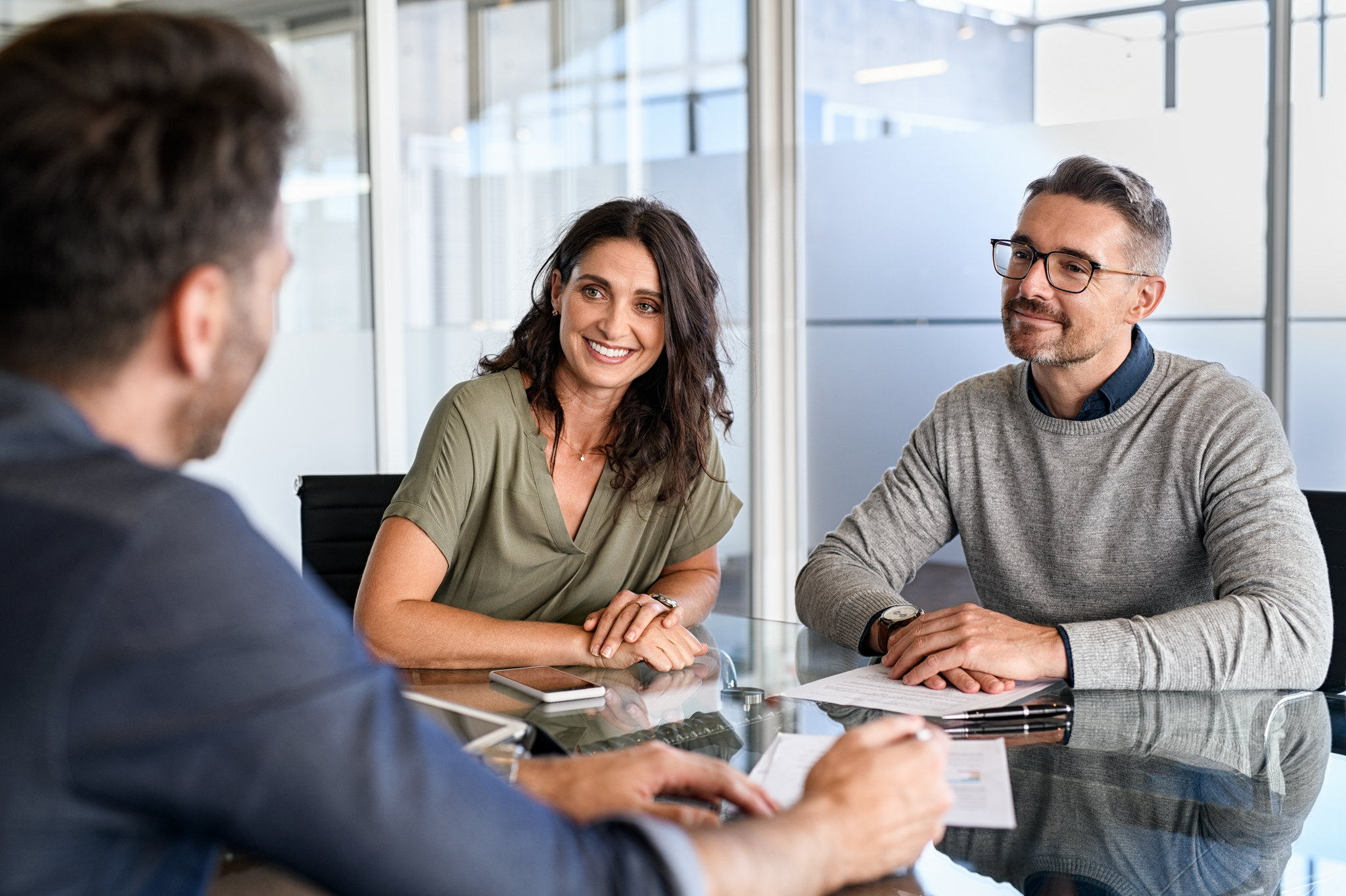 Advisor discussing group insurance options with two clients across a meeting table
