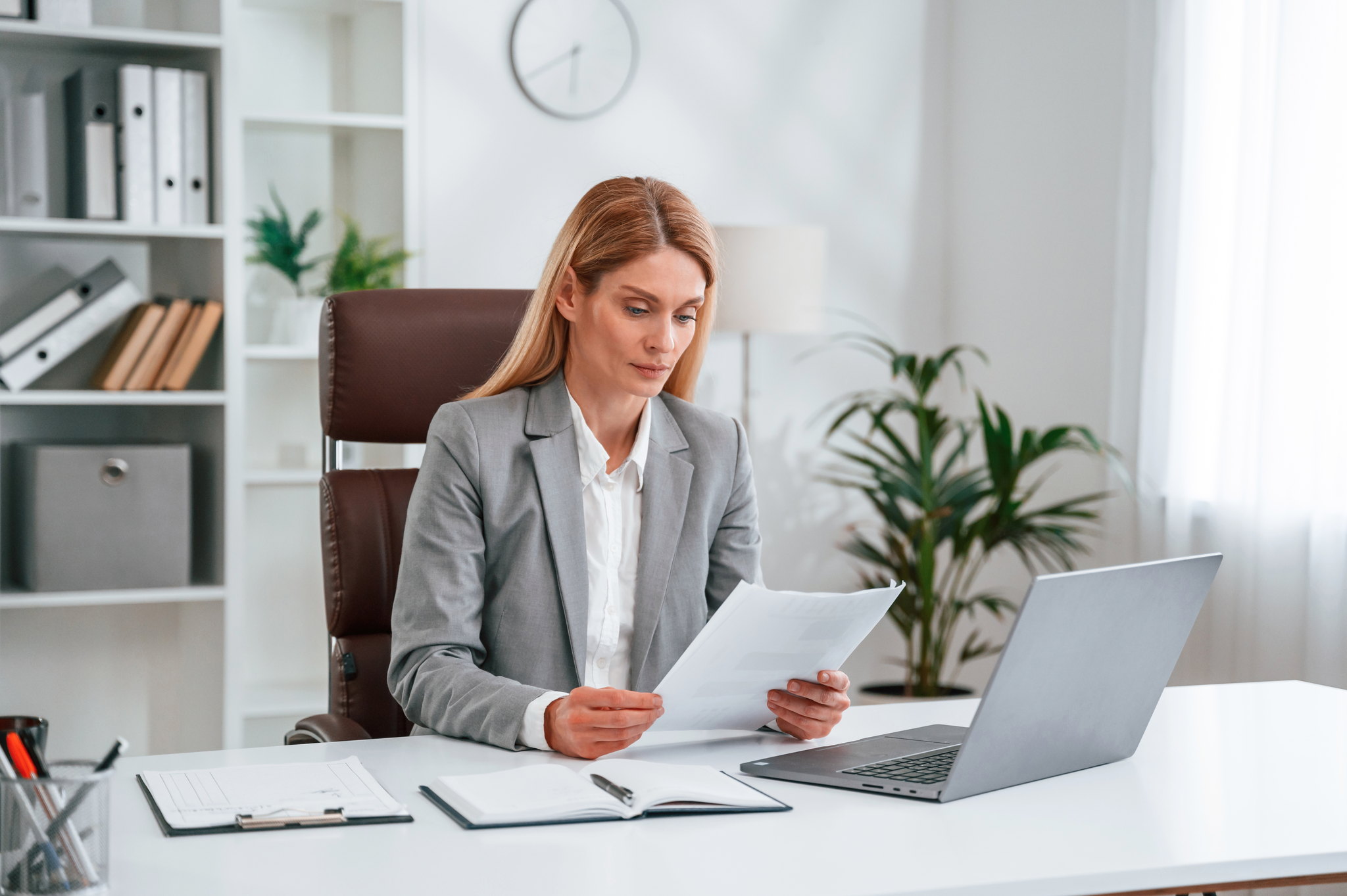 An advisor reviewing workers' compensation loss runs and premium documents at her desk